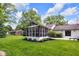 Beautiful backyard with a screened porch, manicured lawn, and mature trees at 445 W 63Rd St, Indianapolis, IN 46260