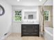 Modern bathroom showcasing a dark vanity, illuminated mirror, and tiled shower, blending style and function at 445 W 63Rd St, Indianapolis, IN 46260