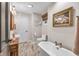 Bathroom featuring a freestanding tub, elegant fixtures, and artistic decor creating a cozy and stylish space at 445 W 63Rd St, Indianapolis, IN 46260