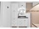 Bright bathroom featuring white vanity and drawers, black countertop, round mirror, and tiled shower at 445 W 63Rd St, Indianapolis, IN 46260