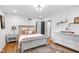 Bright bedroom with a decorative chandelier, white dresser, and cozy bed adorned with stylish pillows and blankets at 445 W 63Rd St, Indianapolis, IN 46260
