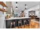 Open kitchen boasts counter seating, wooden shelves, and a view into the dining room at 445 W 63Rd St, Indianapolis, IN 46260