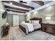 Relaxing main bedroom featuring wood beam ceiling, hardwood floors, neutral paint, and an area rug at 445 W 63Rd St, Indianapolis, IN 46260