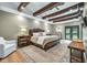 Relaxing main bedroom with wood beam ceiling, hardwood floors, neutral paint and an exterior door at 445 W 63Rd St, Indianapolis, IN 46260