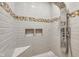 Modern shower with light gray tile, decorative accents, built in shelves, and chrome shower fixtures at 445 W 63Rd St, Indianapolis, IN 46260