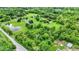 Aerial view of a serene property with pond, mature trees, pool and lush greenery at 4495 W Stones Crossing Rd, Greenwood, IN 46143