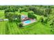 Aerial view of a home with a pool, deck, patio, and a large green lawn surrounded by mature trees at 4495 W Stones Crossing Rd, Greenwood, IN 46143