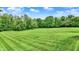 Expansive backyard featuring a lush green lawn and mature trees, perfect for outdoor activities and relaxation at 4495 W Stones Crossing Rd, Greenwood, IN 46143