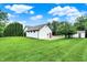Beautiful white home with lush green lawn and mature trees on a sunny day at 4495 W Stones Crossing Rd, Greenwood, IN 46143