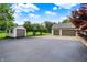 Wide driveway featuring multiple garages, and a storage shed, providing ample space for vehicles and storage at 4495 W Stones Crossing Rd, Greenwood, IN 46143