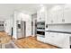 Bright kitchen with stainless steel appliances, white cabinets, and hardwood floors at 4495 W Stones Crossing Rd, Greenwood, IN 46143