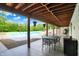 Covered patio with outdoor dining area overlooking the sparkling in-ground pool at 4495 W Stones Crossing Rd, Greenwood, IN 46143