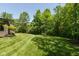 Expansive backyard with a lush green lawn, mature trees, and a glimpse of the home's architecture at 4691 Pascagoula Run, Greenwood, IN 46143