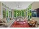 Bright sun room filled with natural light, lush greenery, comfortable seating, and serene views of the surrounding nature at 4691 Pascagoula Run, Greenwood, IN 46143