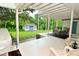 An exterior view of a covered back porch that has chairs, a small table, and a view to a small cottage at 5135 Moller Rd, Indianapolis, IN 46254