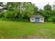 This is an exterior shot of the backyard, with a small cottage and a lush, green lawn at 5135 Moller Rd, Indianapolis, IN 46254