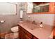 Bathroom features a solid surface vanity, toilet, decorative mirrors, and a gray walls at 5135 Moller Rd, Indianapolis, IN 46254