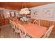 Traditional dining room boasts wood paneled walls, a ceiling, and a large table with seating for eight at 5135 Moller Rd, Indianapolis, IN 46254