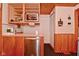 Galley kitchen features stainless steel dishwasher, wood cabinets, and a view of the closet at 5135 Moller Rd, Indianapolis, IN 46254