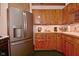 The kitchen features stainless steel refrigerator, wood cabinets, and a green patterned floor at 5135 Moller Rd, Indianapolis, IN 46254