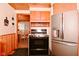 Kitchen featuring stainless steel refrigerator, black oven, and view into the dining room at 5135 Moller Rd, Indianapolis, IN 46254