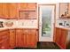 Traditional kitchen with wood cabinets, white countertops, and a door leading to the backyard at 5135 Moller Rd, Indianapolis, IN 46254