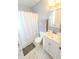 Compact bathroom with a shower-tub combo, white vanity, and neutral gray tiling at 517 Bernard Ave, Indianapolis, IN 46208