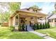 Charming bungalow with a welcoming front porch, lush greenery, and beautiful landscaping at 517 Bernard Ave, Indianapolis, IN 46208