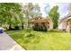 Charming single-Gathering home featuring a well-maintained lawn, lovely garden, and inviting covered porch with beautiful hanging plants at 517 Bernard Ave, Indianapolis, IN 46208