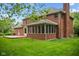 The brick house has a large grassy backyard, patio, and screened-in porch at 5313 Redbird Dr, Columbus, IN 47201