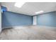 Finished basement space with neutral carpet, light blue walls, and a suspended ceiling with recessed lighting at 5313 Redbird Dr, Columbus, IN 47201