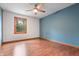 Bedroom with blue accent wall, hardwood floors and a window allowing natural light to flood the space at 5313 Redbird Dr, Columbus, IN 47201