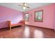 Bright bedroom featuring hardwood floors, ceiling fan and two windows that provide ample natural light at 5313 Redbird Dr, Columbus, IN 47201