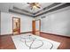 Bedroom with a trey ceiling, wood floors, open door and view into a bathroom at 5313 Redbird Dr, Columbus, IN 47201