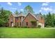 Charming two-story brick home with manicured lawn and mature trees on a sunny day at 5313 Redbird Dr, Columbus, IN 47201