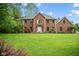 A spacious front yard highlights this two-story brick house, complemented by lush greenery and mature trees at 5313 Redbird Dr, Columbus, IN 47201