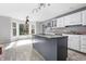 Kitchen featuring gray island, white cabinets, granite countertops, and abundant natural light at 5313 Redbird Dr, Columbus, IN 47201