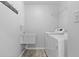 Well-lit laundry room featuring a utility sink, storage rack, and modern washer and dryer at 5313 Redbird Dr, Columbus, IN 47201