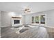 Bright living room with fireplace, ceiling fan, and doors leading to an outdoor patio at 5313 Redbird Dr, Columbus, IN 47201