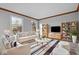 Cozy living room with natural light, neutral furniture, decorative shelving and hardwood flooring at 5313 Redbird Dr, Columbus, IN 47201