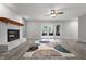 Bright living room featuring a painted brick fireplace, ceiling fan, and sliding glass doors at 5313 Redbird Dr, Columbus, IN 47201