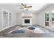Open living room with a brick fireplace, ceiling fan, and French doors leading to the patio at 5313 Redbird Dr, Columbus, IN 47201