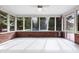 Bright sunroom featuring brick accents, white tile flooring, and large windows overlooking the backyard at 5313 Redbird Dr, Columbus, IN 47201