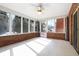 Bright sunroom with brick accents, white tile flooring, and large windows offering backyard views at 5313 Redbird Dr, Columbus, IN 47201