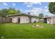 Backyard view of home with stone fire pit, lawn, and shed at 5326 Brazos Dr, Indianapolis, IN 46237