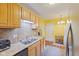 Efficient kitchen design with light wood cabinets, a stainless steel refrigerator, and a utility closet at 5326 Brazos Dr, Indianapolis, IN 46237