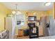 Traditional kitchen featuring wood cabinets, black appliances, and yellow walls provides cozy cooking space at 5326 Brazos Dr, Indianapolis, IN 46237