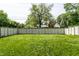 View of the backyard with a wooden fence and lush green grass at 5401 N New Jersey St, Indianapolis, IN 46220