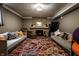 Finished basement featuring a brick fireplace, neutral colored sofas and a colorful rug at 5401 N New Jersey St, Indianapolis, IN 46220