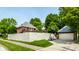 View of garage and fenced yard including basketball hoop and brick home with upper level deck at 5401 N New Jersey St, Indianapolis, IN 46220